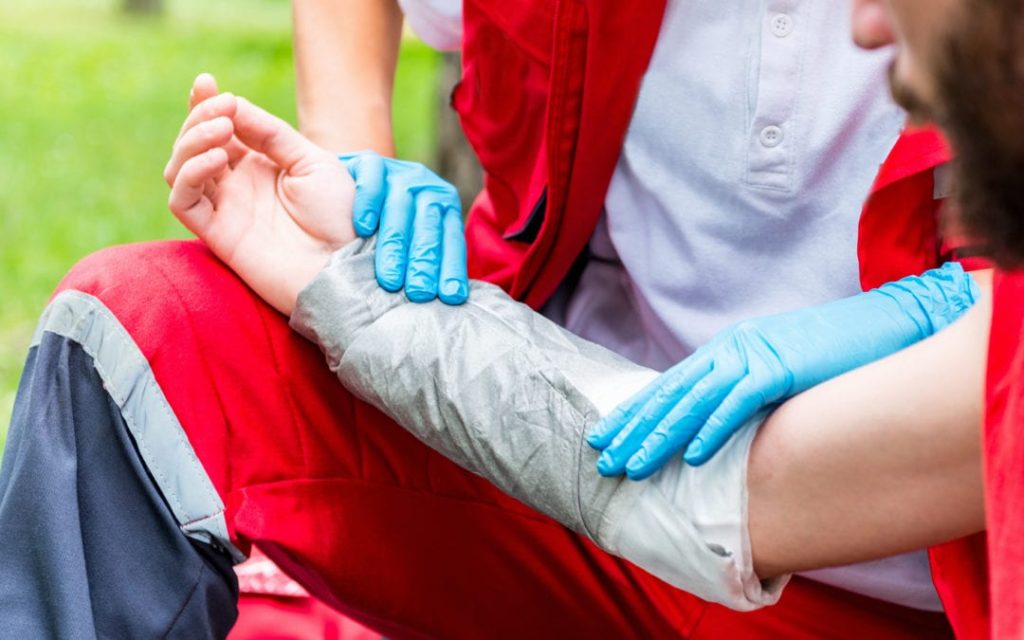 A medical worker in gloves bandaging a burned arm