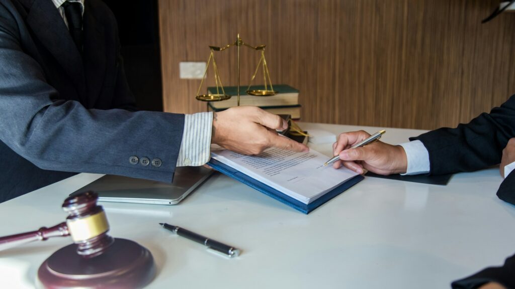 Attorney reviewing a settlement document at a desk with scales of justice