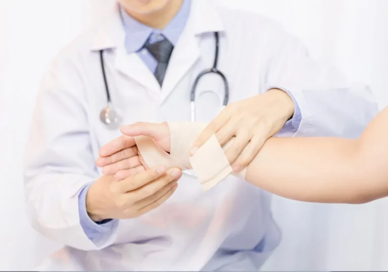 Doctor wrapping a bandage around an injured patient's arm