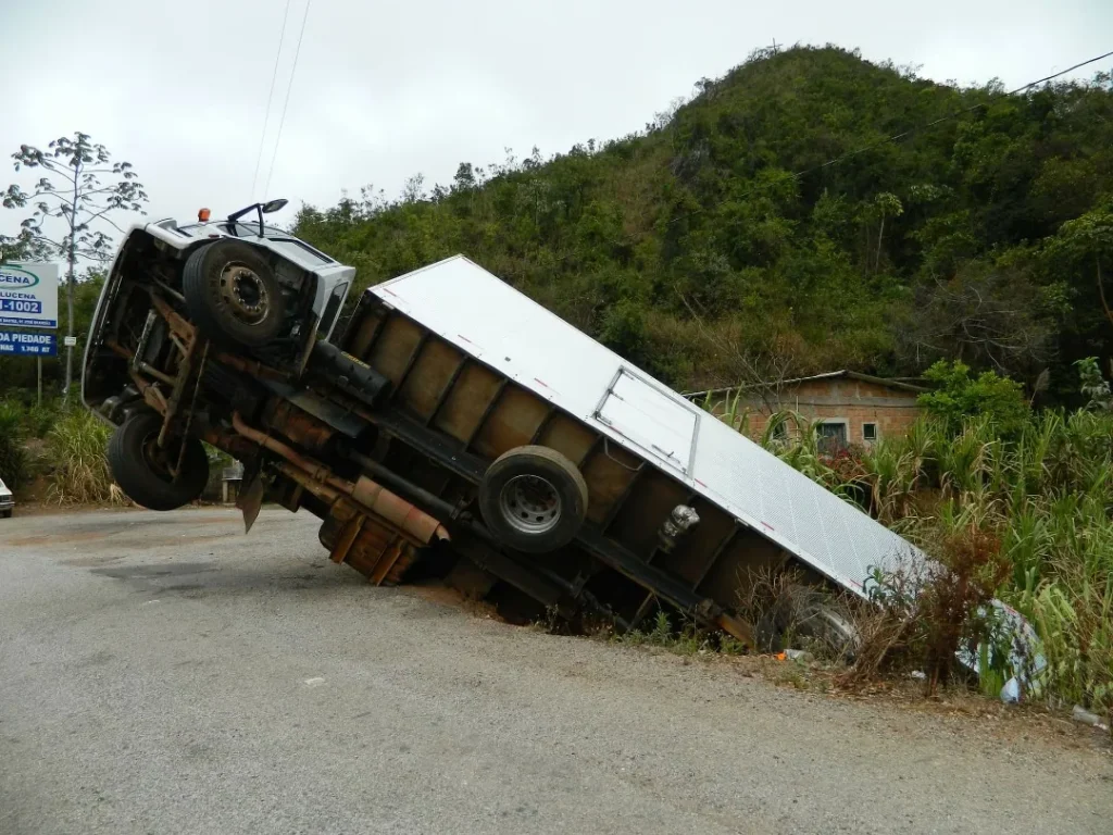 A box truck tipped over at the side of a road